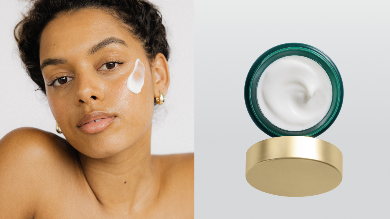 Woman applying cream to her face with a jar of cream on a white background
